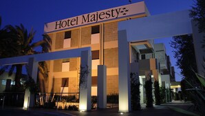 Hotel Majesty, con un diseño arquitectónico moderno, que presenta un llamativo letrero de entrada y una fachada bien iluminada.