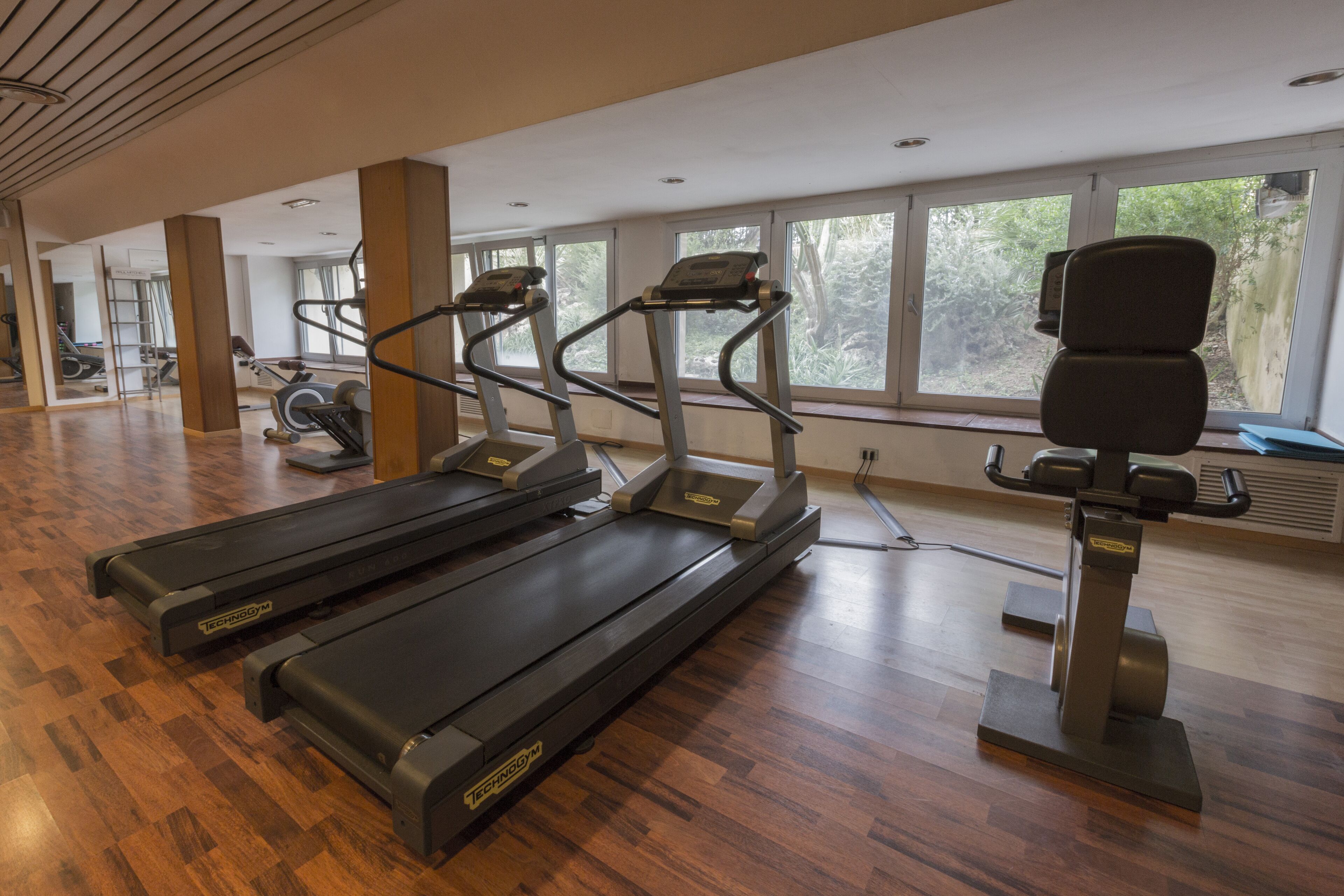 A gym with treadmills, exercise bikes, and a rowing machine.