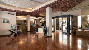 A spacious lobby with a polished marble floor, a central staircase, and a glass door entrance. - Hotel Vello d'Oro (Taormina)