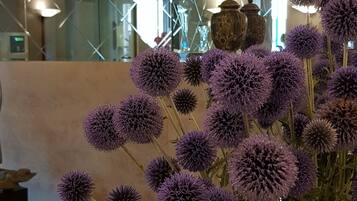 Un vase blanc orné de fleurs violettes, posé sur une table en bois.
