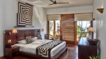A spacious bedroom with a large bed, wooden headboard, and a ceiling fan.