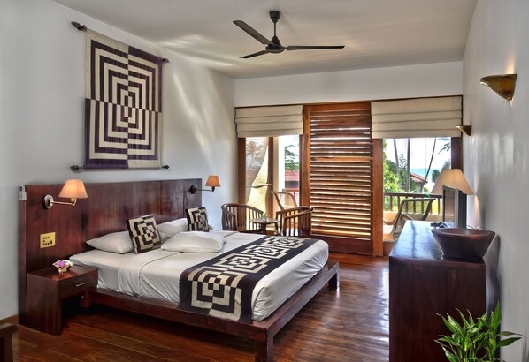 A spacious bedroom with a large bed, wooden headboard, and a ceiling fan. - Weligama Bay Resort (Weligama)