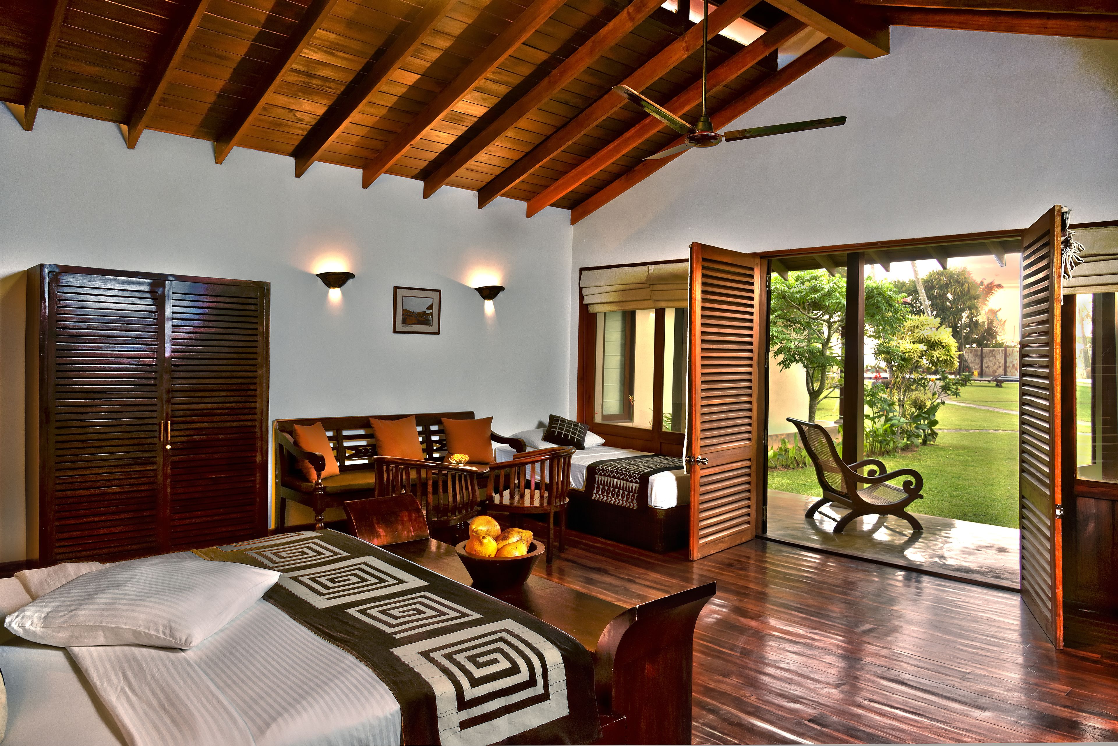 Un dormitorio con cama, zona de estar, mesa de comedor y vistas al exterior.