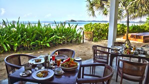 A table set for breakfast with a view of the beach and ocean. - Weligama Bay Resort (Weligama)