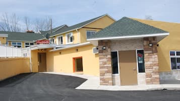 A yellow building with a 'Cocktails' sign, a stone entrance, and a 'UP!' sign on the door.