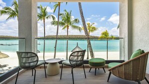 A balcony with wicker furniture, a view of the beach, and palm trees. - Shandrani Beachcomber Resort & Spa (Blue Bay)