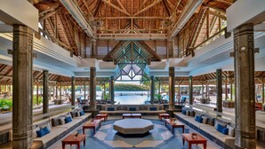 A spacious lobby with a central seating area, a pool view, and a tropical architectural design. - Shandrani Beachcomber Resort & Spa (Blue Bay)