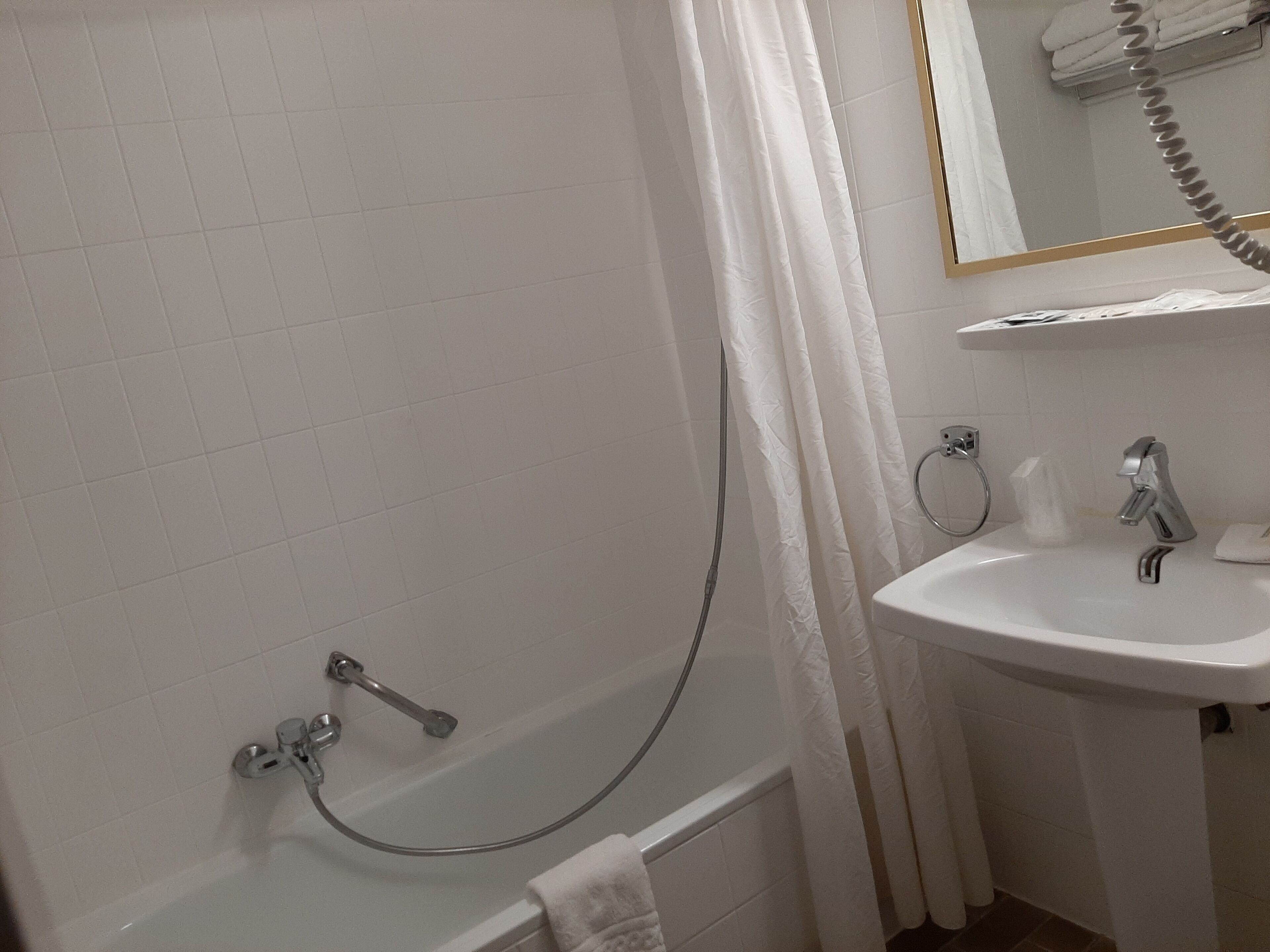 Une salle de bain avec une baignoire, un lavabo et un porte-serviettes.