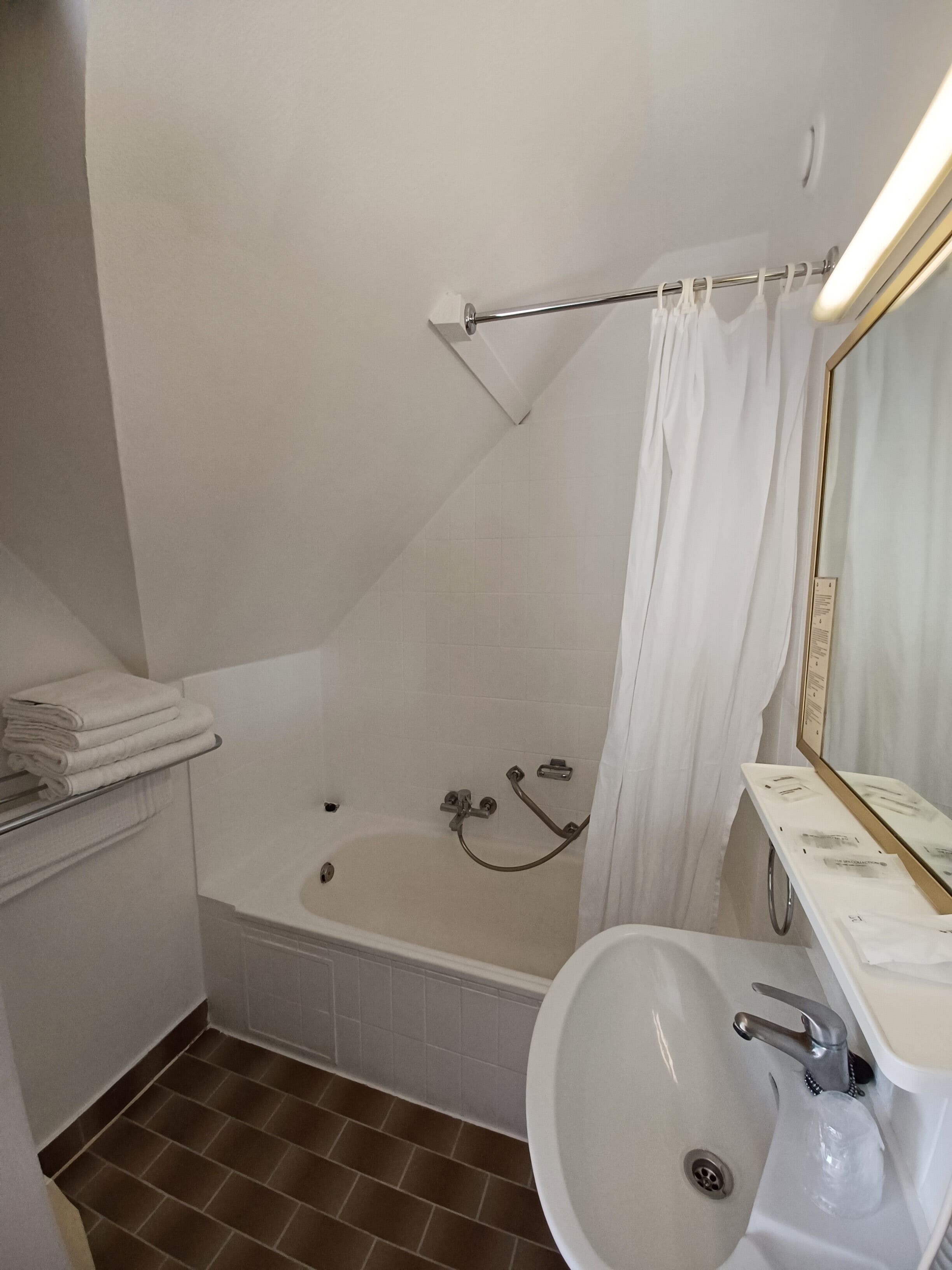 Un baño con bañera, lavabo y espejo.