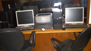 A workspace with two monitors, a printer, and two office chairs. - Athens Moka Hotel (Athens)