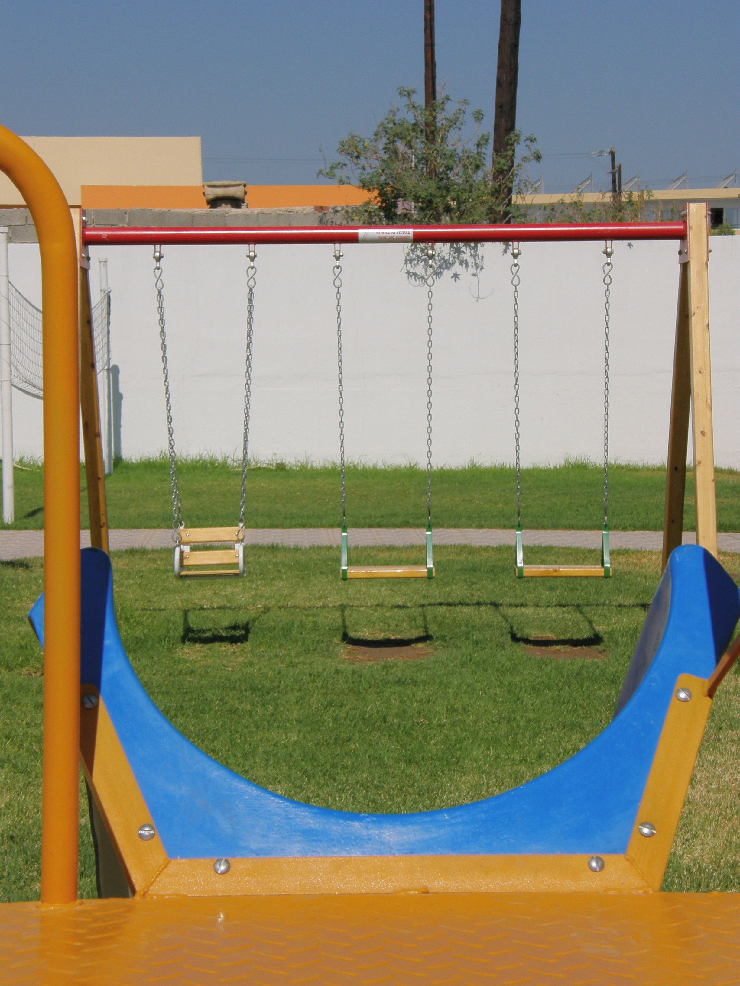 Une aire de jeux avec des balançoires et un toboggan.
