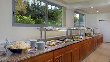 Un buffet proposant une variété de plats, avec une vue sur la verdure environnante.