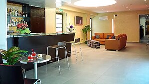 A lobby with a reception desk, seating area, and a large window. - Hotel Dei Vicari (Scarperia e San Piero)