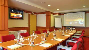 A conference room with a long table set for a meeting, equipped with chairs, water bottles, and glasses.