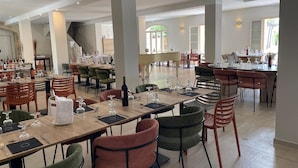 A spacious dining area with multiple tables and chairs, a piano, and a staircase leading to an upper level. - Best Western Le Clos de l'Aube Rouge (Castelnau-le-Lez)