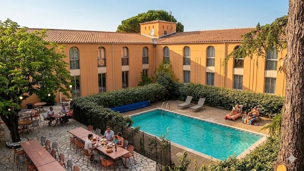 A courtyard with a swimming pool, outdoor seating, and a building with multiple windows. - Best Western Le Clos de l'Aube Rouge (Castelnau-le-Lez)