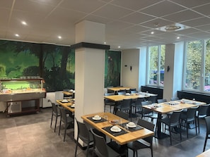 A restaurant with multiple tables, chairs, and a buffet area. - Hôtel Esplanade (Strasbourg)
