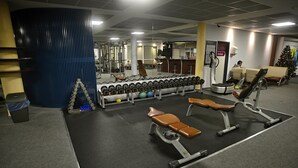 Una palestra con attrezzature per esercizi, panche e un albero di Natale.