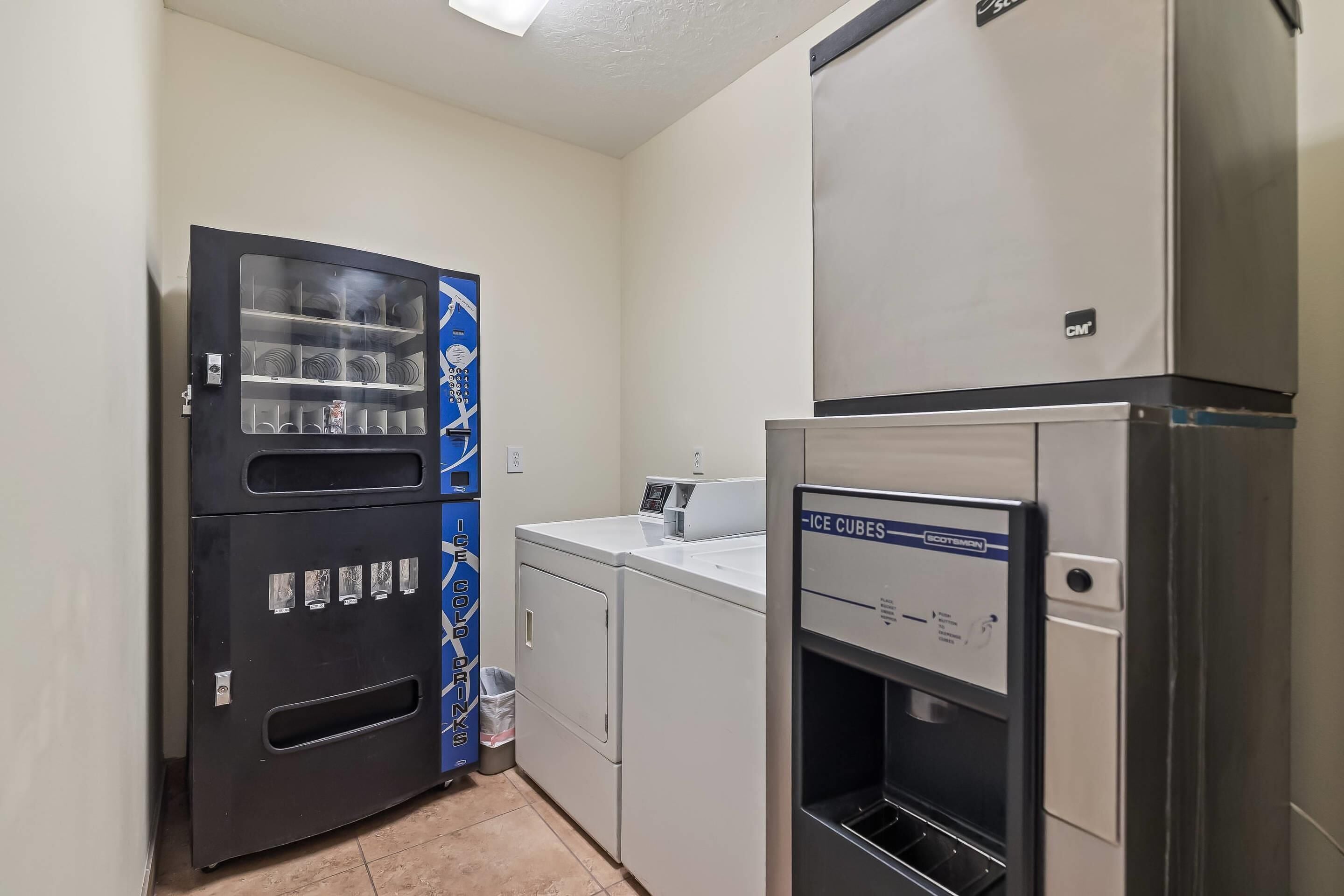A laundry room with a vending machine, a washing machine, and an ice dispenser.