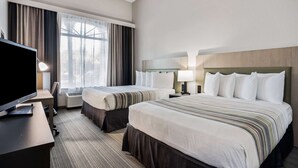 A hotel room with two beds, a desk with a television, and a large window with curtains. - Country Inn & Suites by Radisson, Port Canaveral, FL (Cape Canaveral)