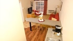 A compact living space with a kitchenette, a dining area with a table and chairs, and a window with curtains. - Sky City Casino Hotel (San Fidel)