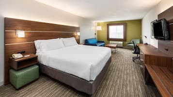 Una habitación de hotel con una cama grande, un escritorio, una silla, un televisor y una ventana.