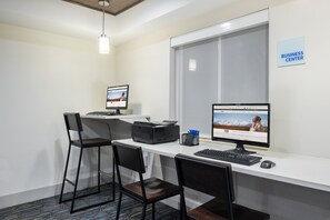 A business center with two computer workstations, chairs, a printer, and a window with blinds. - Holiday Inn Express Warrenton by IHG (Warrenton)