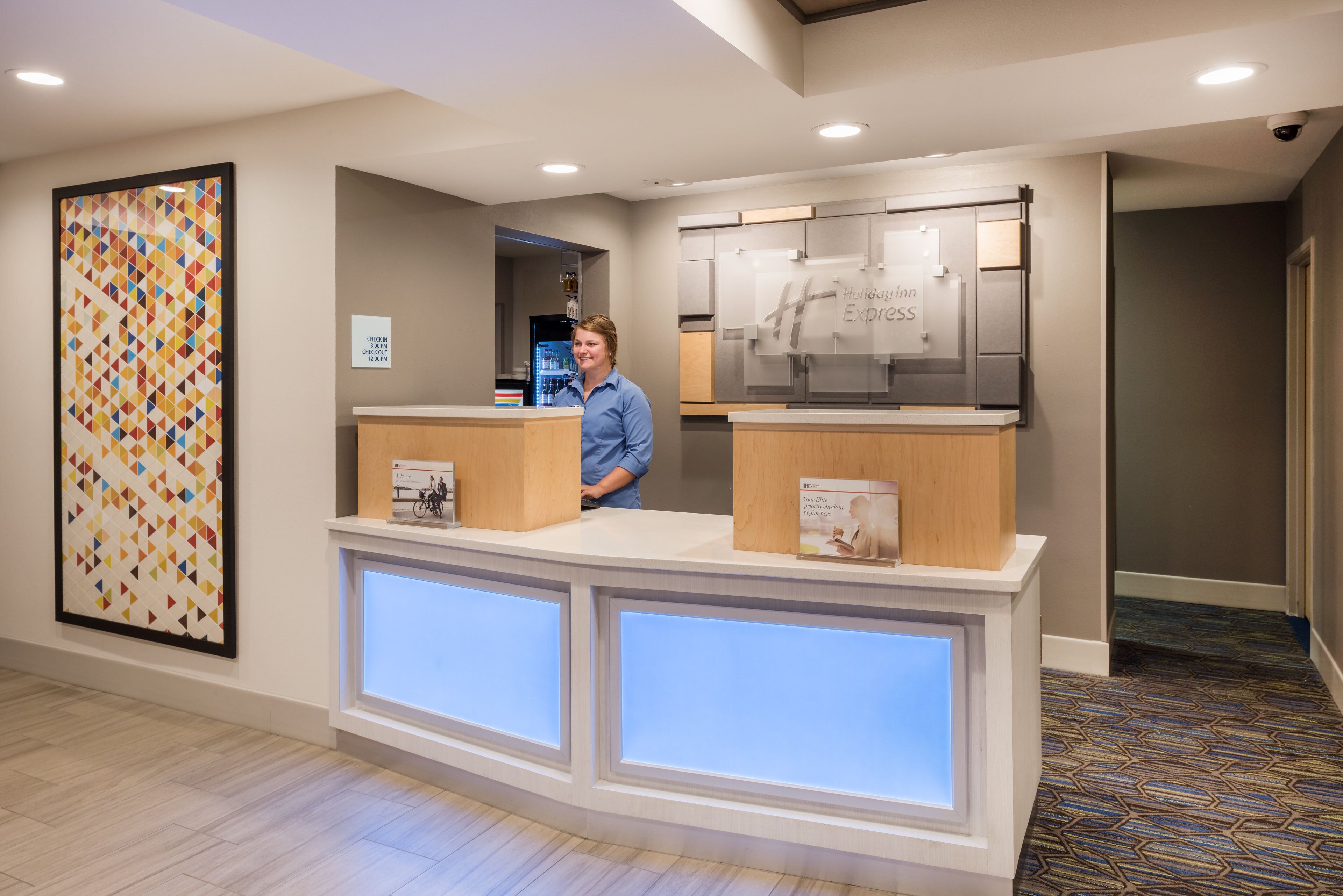 En hotelfri reception med digital skærm, en check-in/check-out skiltning og et Holiday Inn Express skilt.