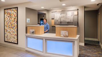 En hotelfri reception med digital skærm, en check-in/check-out skiltning og et Holiday Inn Express skilt.