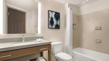 A modern bathroom with a sink, toilet, and bathtub.