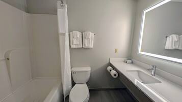 A modern bathroom with a bathtub, toilet, and sink.