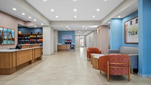 A modern hotel lobby with a reception desk, seating area, and a snack bar. - Hampton Inn & Suites Waxahachie (Waxahachie)