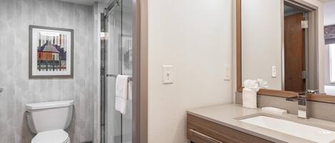 Une salle de bain moderne équipée de toilettes, d’une douche et d’un lavabo.