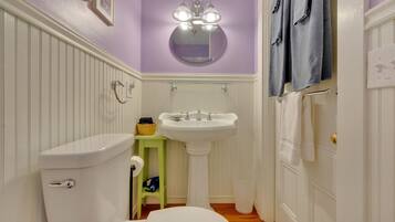 Baño con inodoro, lavamanos y espejo.