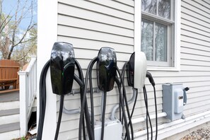 Tres estaciones de carga para vehículos eléctricos instaladas en la fachada de una casa.