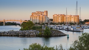 A marina with boats, a bridge, and a hotel with multiple floors and balconies.