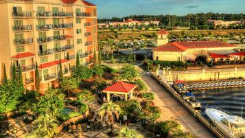 A hotel with multiple balconies, a swimming pool, and a dock with boats.
