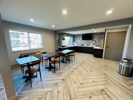 Una cocina moderna con piso de espiga, una isla integrada y un televisor de pantalla plana montado en la pared.