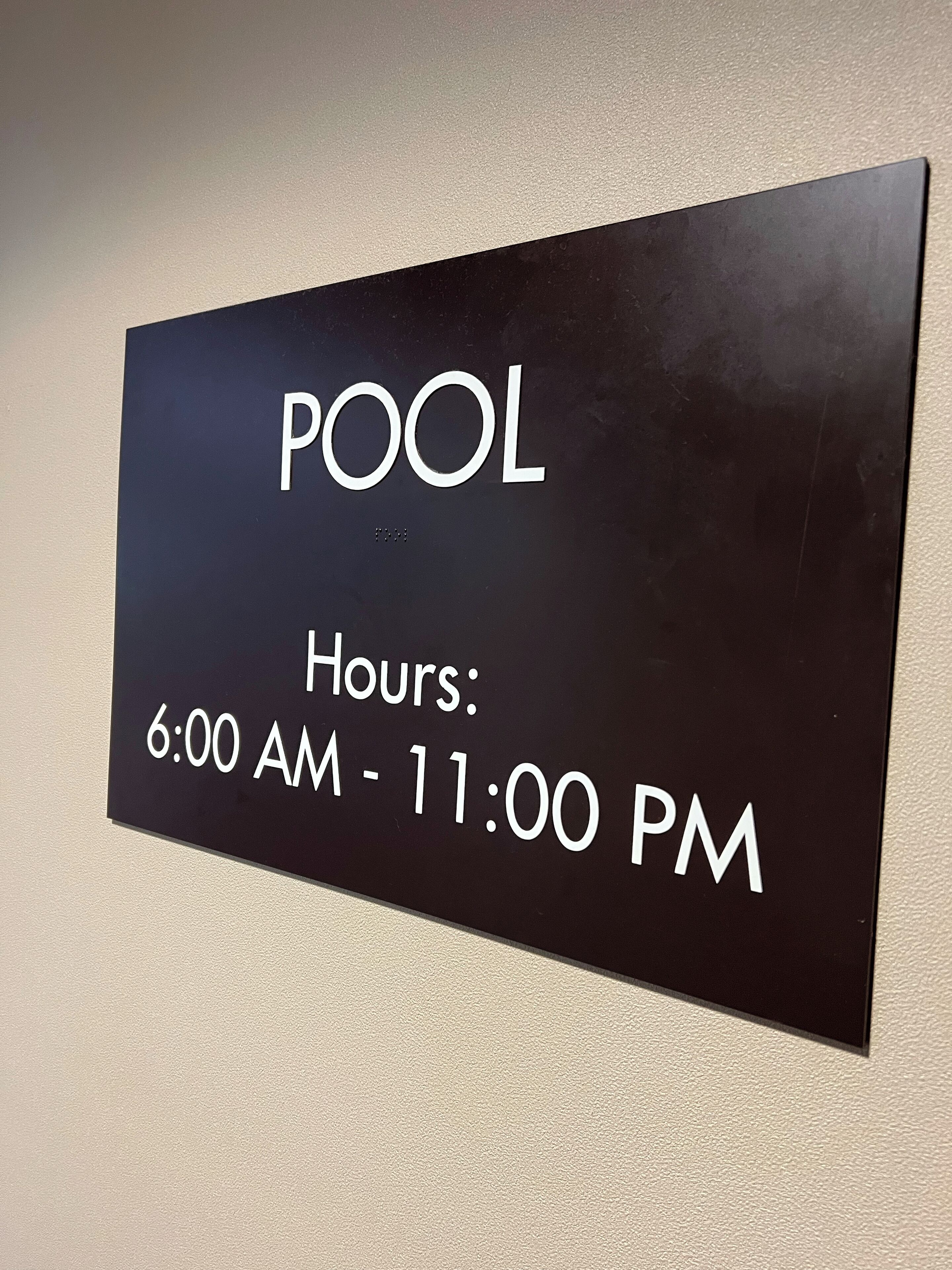 Señal que indica el horario de la piscina: 6:00 a.m. a 11:00 p.m.