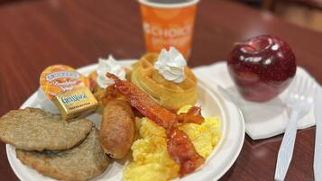 A breakfast plate with eggs, bacon, sausage, and toast.