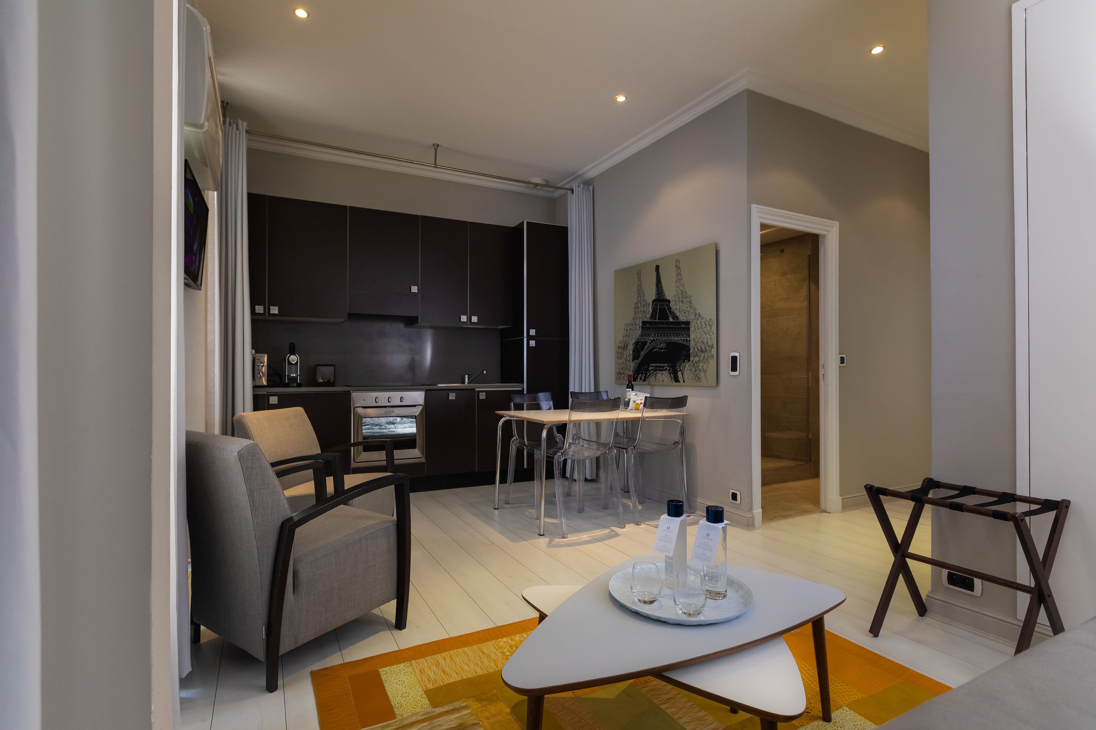 A modern living room with a sofa, a coffee table, and a dining area with a table and chairs.