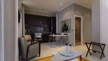 A modern living room with a sofa, a coffee table, and a dining area with a table and chairs.