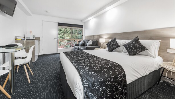 A modern hotel room with a bed, a desk, and a chair. - Bay City Motel Geelong (Geelong)