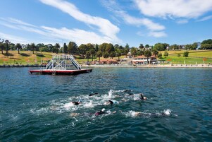 A waterfront swimming area with a lifeguard tower and a dock.