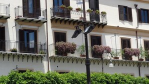A multi-story building with balconies, each with potted plants. - Casa Giuditta Appartamenti (Palermo)