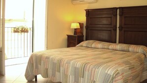 A bedroom with a bed, a nightstand, a lamp, a wall-mounted air conditioner, and a picture frame. - Casa Giuditta Appartamenti (Palermo)