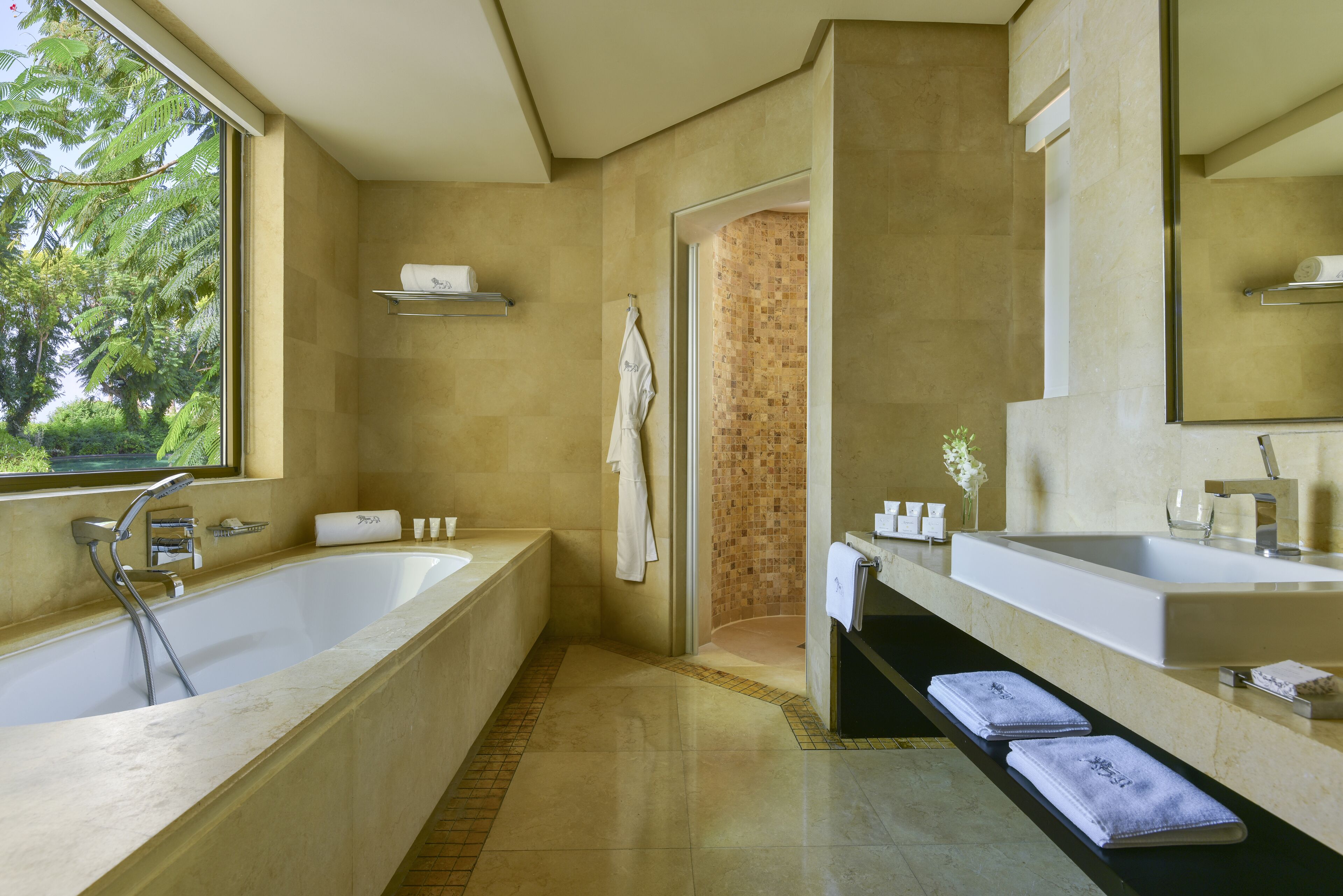 Een moderne badkamer met een ruime badkuip, een aparte douche en een wastafel met spiegel.