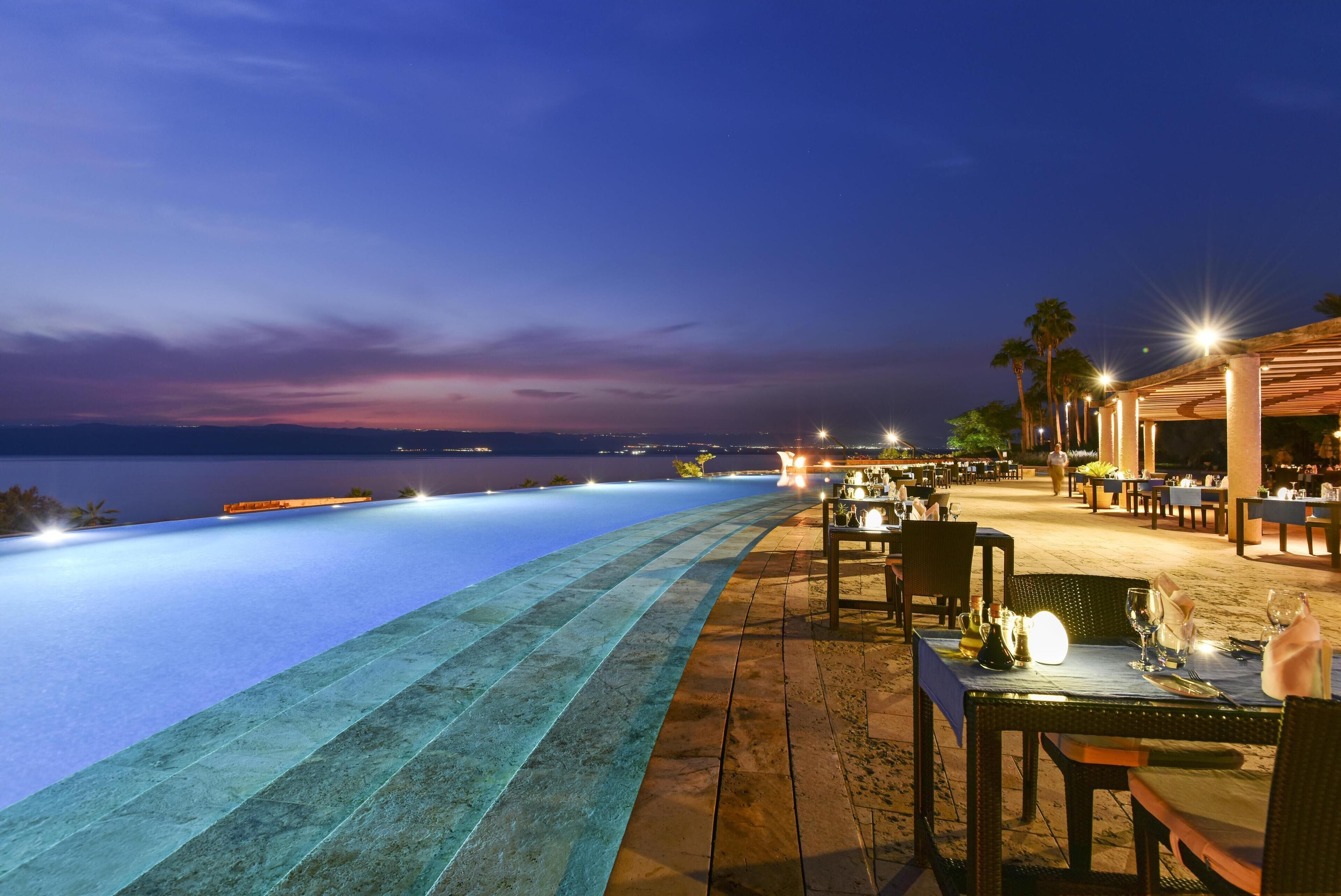 An infinity pool with a view of the sea at dusk.