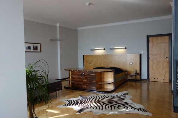 A modern bedroom with a wooden headboard, a zebra-patterned rug, and a bedside table.