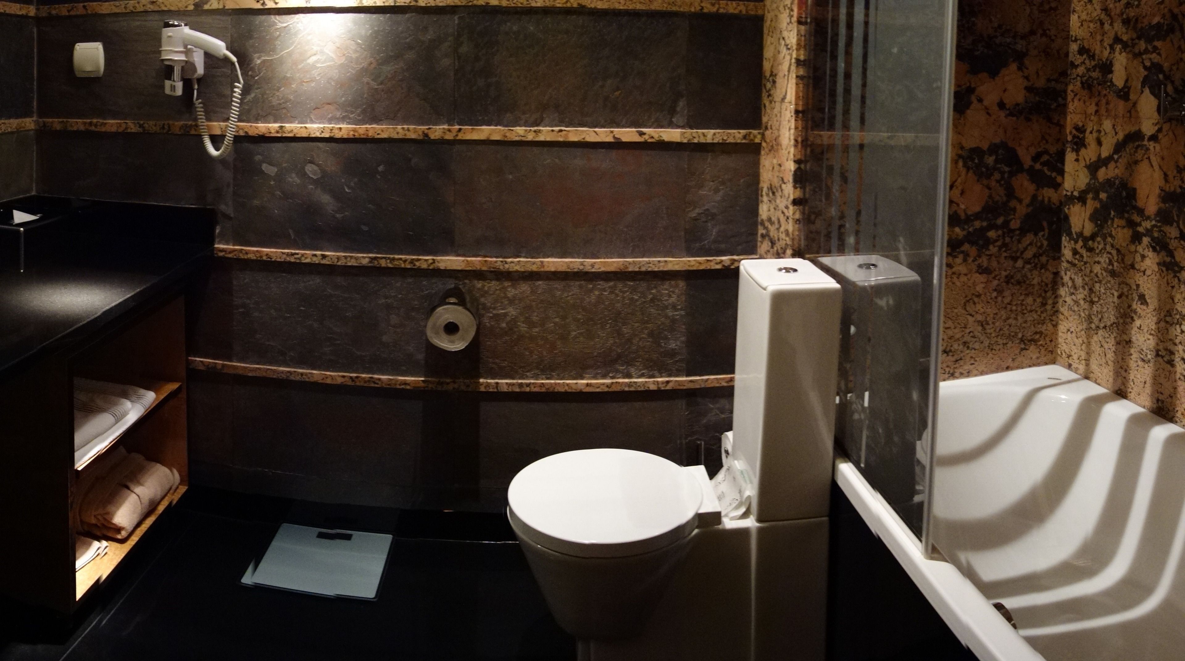 A bathroom with a toilet, a sink, and a shower area.